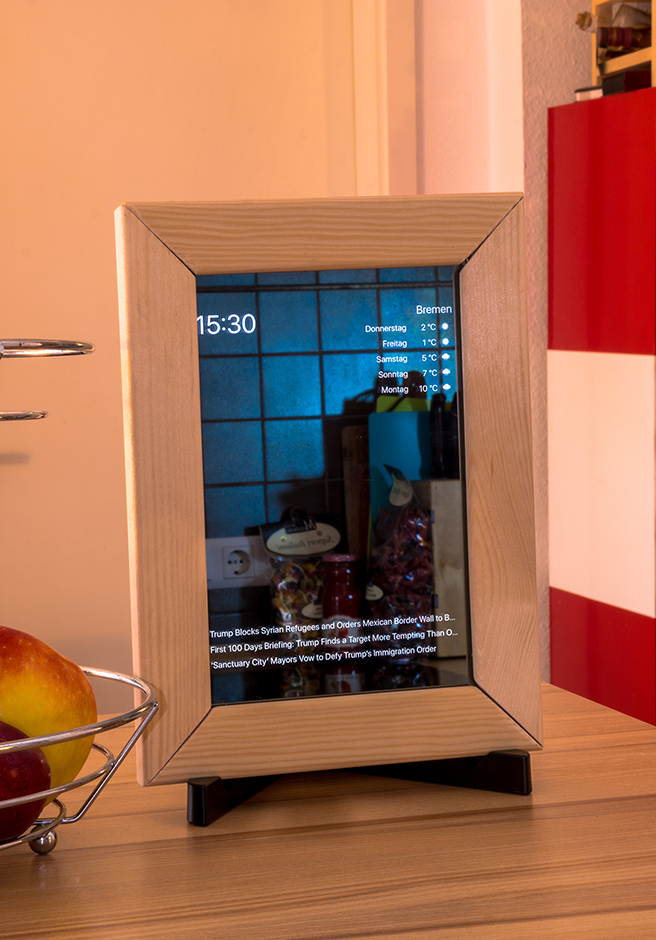 Photograph of a wooden framed mirror with weather and calendar events projected onto the glass